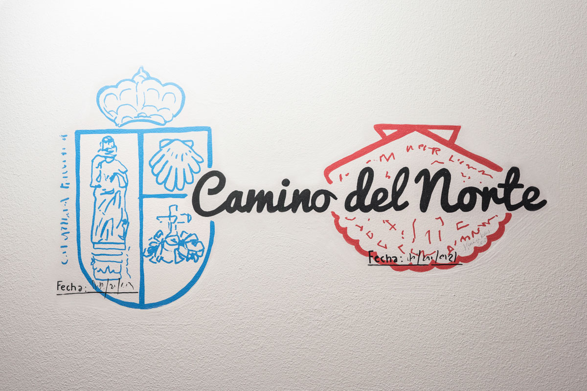 Ilustración en pared de sellos y escrito Camino del Norte.